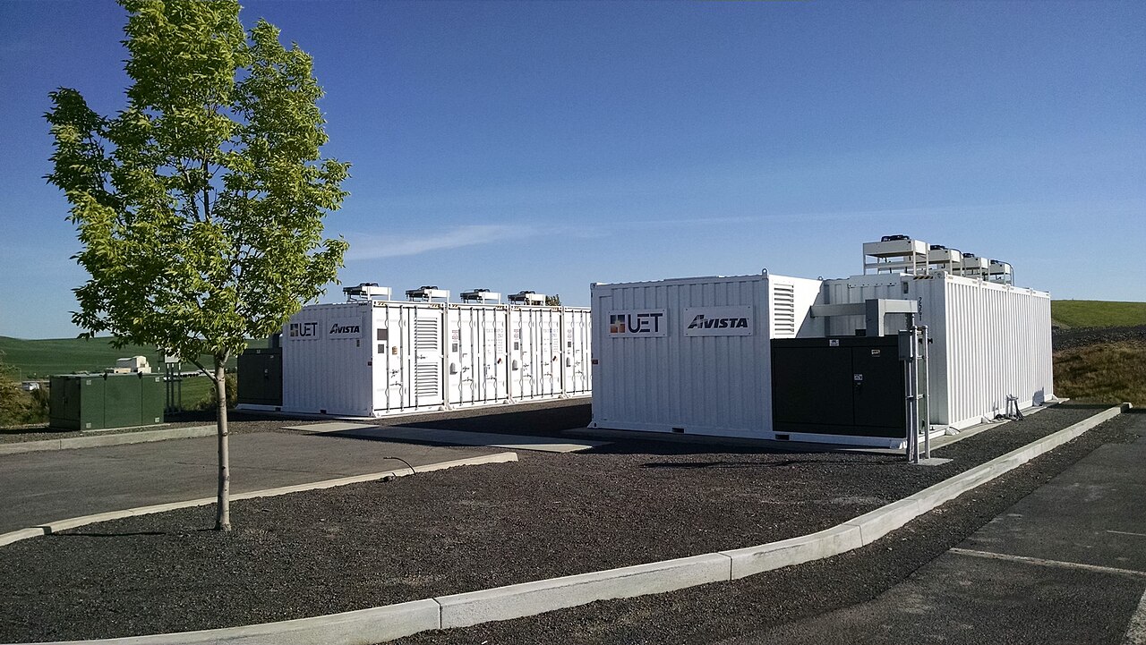 Containerized 1 MW / 4 MWh battery energy storage project with white shipping containers and a power conversion container.